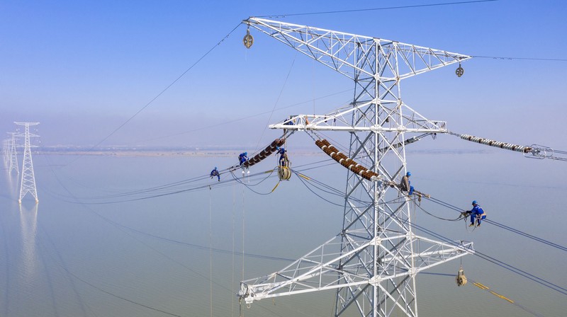 2021年10月，江蘇省送變電有限公司施工人員在太湖高空架設導線。圖/東方IC